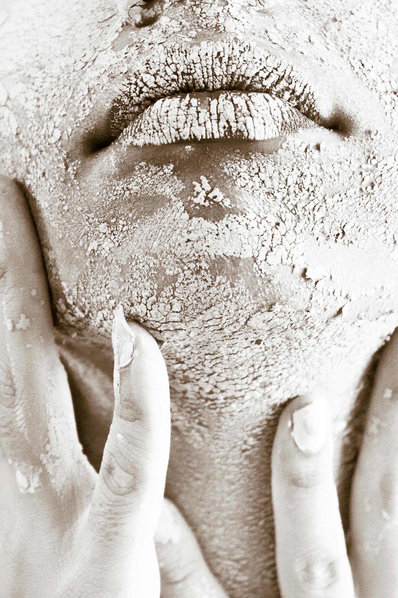 makeup artist using makeup melt spray on client with dry, flaky skin