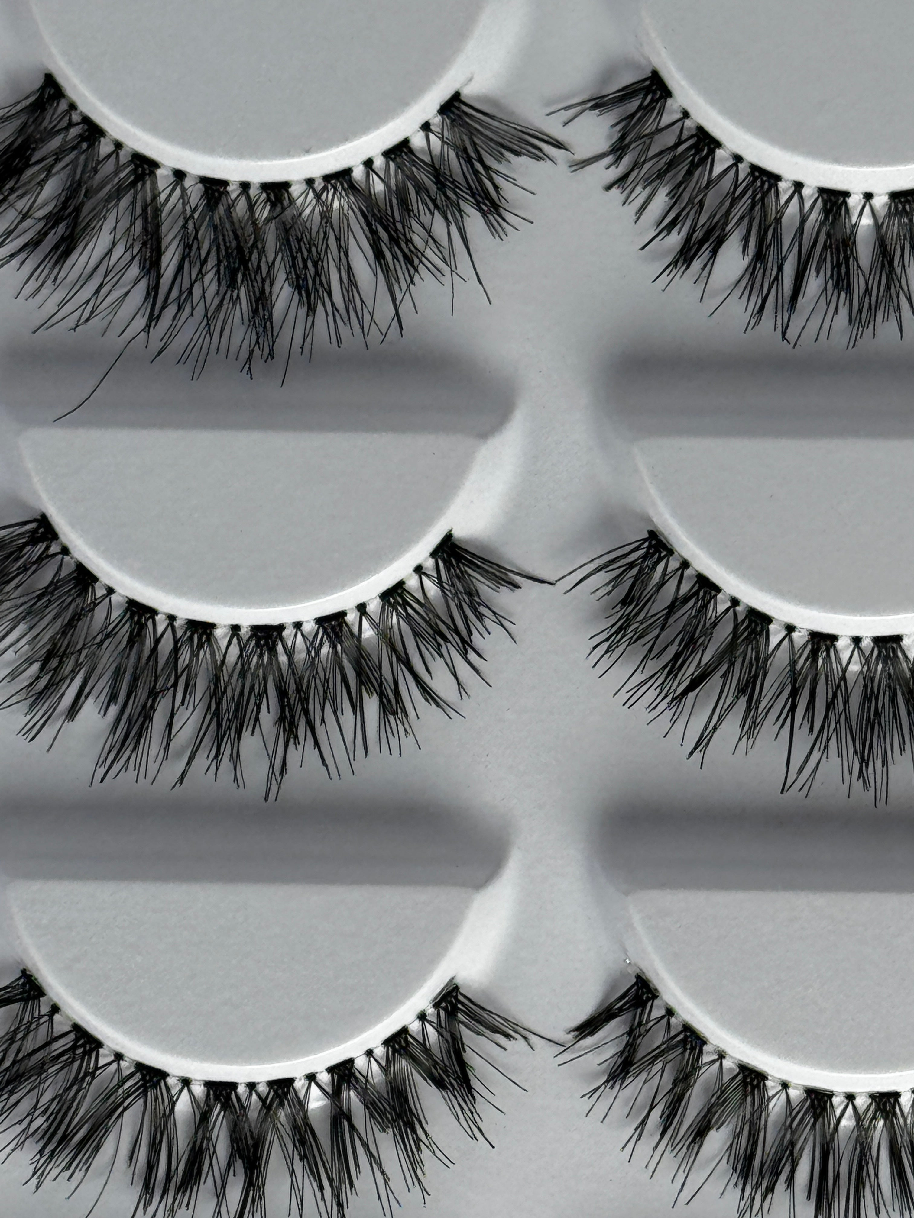 Wispy strip false eyelashes on a lash tray, lightweight for everyday wear